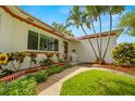 Charming home with vibrant flower beds, a walkway leading to the front door, and mature palm trees at 5800 3Rd S St, St Petersburg, FL 33705