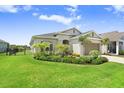 Beautifully landscaped front yard with a charming single-story home, enhanced by green grass and blue skies at 6097 Golden Nettle Dr, Apollo Beach, FL 33572