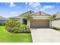 Lovely single-story home with lush landscaping, featuring palm trees and a well-maintained lawn at 6097 Golden Nettle Dr, Apollo Beach, FL 33572