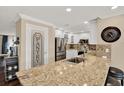 Modern kitchen featuring granite countertops, stainless steel appliances, white cabinetry, and a pantry door at 6219 Wendell Dr, Wesley Chapel, FL 33544