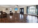 Bright living room with hardwood floors, a fireplace, large windows, and an elegant entry at 6219 Wendell Dr, Wesley Chapel, FL 33544