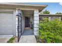 View of front entrance through decorative gate showing covered porch at 6310 Gainsboro Ave, Spring Hill, FL 34609
