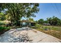 Street view of the home showing the long driveway and simple landscaping at 6618 N 11Th St, Tampa, FL 33604