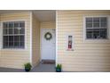 Close-up of a condo front door with windows, house plants and a fire extinguisher at 6817 Stones Throw N Cir # 17203, St Petersburg, FL 33710