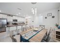 Inviting dining area with a decorative chandelier and a view into the modern, open-concept kitchen at 71 Rose Bud Ln, Spring Hill, FL 34609