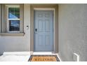 Charming front door entrance with a Welcome mat, secure lock and doorbell, framed by an inviting window at 71 Rose Bud Ln, Spring Hill, FL 34609