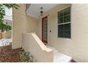 Inviting front entrance with a charming red door, concrete steps, and a convenient window at 918 Sombra Street, Tampa, FL 33619