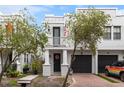 Charming townhome featuring a private entrance with a balcony, garage, and mature landscaping at 109 S Packwood Ave # B, Tampa, FL 33606