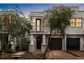 Charming two-story home features a balcony, columns, and a two-car garage at dusk at 109 S Packwood Ave # B, Tampa, FL 33606