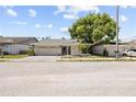 Charming one-story home with a well-maintained lawn, palm tree, and attached two-car garage at 10900 Livingston Dr, New Port Richey, FL 34654