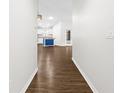 Inviting hallway with wood-look flooring, leading to a kitchen featuring a blue island at 10900 Livingston Dr, New Port Richey, FL 34654