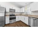 Modern kitchen with stainless steel appliances, granite countertops, and bright white cabinets at 10900 Livingston Dr, New Port Richey, FL 34654