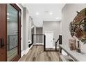 Bright and inviting hallway with hardwood floors, modern fixtures, and staircase access at 110 Carlyle Dr, Palm Harbor, FL 34683