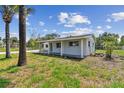 Side view of a cozy home showcasing a covered patio and lush green lawn, ideal for outdoor living at 1110 Canal St, Ruskin, FL 33570