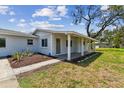 Inviting front porch with tiled flooring, decorative landscaping, and a welcoming green front door at 1110 Canal St, Ruskin, FL 33570