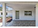 Covered front porch featuring tile flooring, a green entry door, and ample space for relaxation at 1110 Canal St, Ruskin, FL 33570