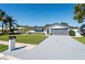 An attractive front exterior with a large lawn, minimalist landscaping, and a two-car garage at 14261 113Th Ave, Largo, FL 33774