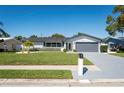 Landscaped front yard, white brick, new roof, and a grey two-car garage give this home great curb appeal at 14261 113Th Ave, Largo, FL 33774