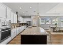 Modern kitchen featuring granite countertops, stainless steel appliances, a large island, and pendant lighting at 1767 Tonka Ter, Wesley Chapel, FL 33543