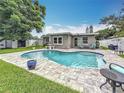 Inviting backyard oasis featuring a kidney-shaped pool and patio seating at 1921 Ridgewood Dr, Clearwater, FL 33763