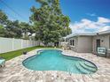 Relaxing backyard with a spacious pool, patio area, and lush green lawn at 1921 Ridgewood Dr, Clearwater, FL 33763