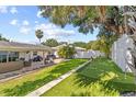 Expansive backyard featuring a putting green, patio seating, and lush landscaping at 1960 Sever Dr, Clearwater, FL 33764