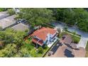 An aerial view of the home and its serene backyard, complete with a patio, mature trees and lush green grass at 2015 Long Branch Ln, Clearwater, FL 33760