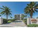 Beautiful Harborage II building featuring lush landscaping and mature palm trees at 240 Sand Key Estates Dr # 222, Clearwater, FL 33767