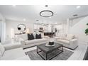 Bright living room with contemporary sofas, modern decor, and an open layout connecting to the kitchen at 30572 Thunderbird Dr, Wesley Chapel, FL 33545