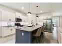 Bright kitchen features granite counters, a dark island with seating, stainless appliances and subway tile backsplash at 32825 Sand Creek Dr, Wesley Chapel, FL 33543