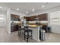 Kitchen featuring an island with granite countertops, dark wood cabinets, and stainless steel appliances at 3334 Pleasant Willow Ct, Brandon, FL 33511