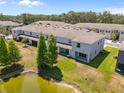 Exterior rear view of townhomes with covered patios, lawn, and pond at 3334 Pleasant Willow Ct, Brandon, FL 33511