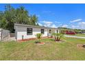Side view of a freshly painted single-story home with manicured lawn and new landscaping at 4812 El Capistrano Dr, Tampa, FL 33634