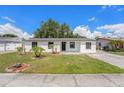Charming single-story home with fresh white paint, dark trim, manicured lawn, and landscaping at 4812 El Capistrano Dr, Tampa, FL 33634
