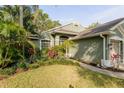 Front exterior view with lush landscaping and a view of the entranceway at 5619 Essex Ct, Palm Harbor, FL 34685