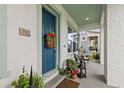 Charming covered porch with a blue front door accented with flowers, plants, and stylish outdoor furniture at 702 34Th N Ave, St Petersburg, FL 33704