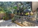 Landscaped backyard with a wooden deck and gazebo creating a tranquil outdoor retreat at 7461 Pescador Pl, Seminole, FL 33772