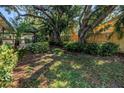 Serene backyard featuring lush landscaping, mature trees, and a cozy gazebo at 7461 Pescador Pl, Seminole, FL 33772
