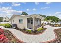 Quaint home showcasing a screened front porch, attractive landscaping, and a brick-lined walkway at 807 Illinois Ave, Palm Harbor, FL 34683