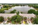Aerial view of townhomes in a community with a serene lake and lush greenery at 8568 Sandy Beach St, Tampa, FL 33634