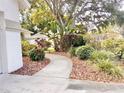 Landscaped front yard with mature trees and mulched flower beds at 9191 64Th N Way, Pinellas Park, FL 33782
