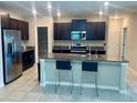 Modern kitchen featuring stainless steel appliances, dark wood cabinetry, and a granite island at 9520 Lemon Drop Loop, Sun City Center, FL 33573