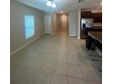 Spacious living room with tile flooring, neutral paint, and natural light from a window at 9520 Lemon Drop Loop, Sun City Center, FL 33573