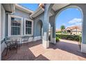 Covered patio with brick flooring, offers an outdoor seating area, and views of the neighborhood at 10645 Ruffino Ct, Trinity, FL 34655