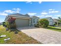 Charming single-story home with a well-manicured lawn and brick paved driveway at 1110 Jasmine Creek Ct, Sun City Center, FL 33573