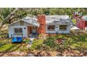 Quaint single-story home with a brick chimney, surrounded by lush greenery, creating a serene setting at 11912 Mcmullen Loop, Riverview, FL 33569