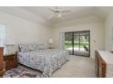 Light, bright, and airy primary bedroom featuring neutral carpet, a ceiling fan, and sliding glass doors to the outside at 120 Fernbrook Rd, Oldsmar, FL 34677