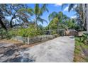 Quaint single-story house with a well manicured lawn, white picket fence, and spacious driveway at 12304 Woodleigh Ave, Tampa, FL 33612