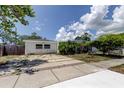 Inviting single-story home featuring a spacious driveway and lush landscaping in a peaceful setting at 1242 Bermuda St, Clearwater, FL 33755