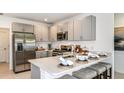 Modern kitchen featuring stainless steel appliances, quartz countertops, breakfast bar and sleek cabinetry at 12469 Gust Ct, Hudson, FL 34669